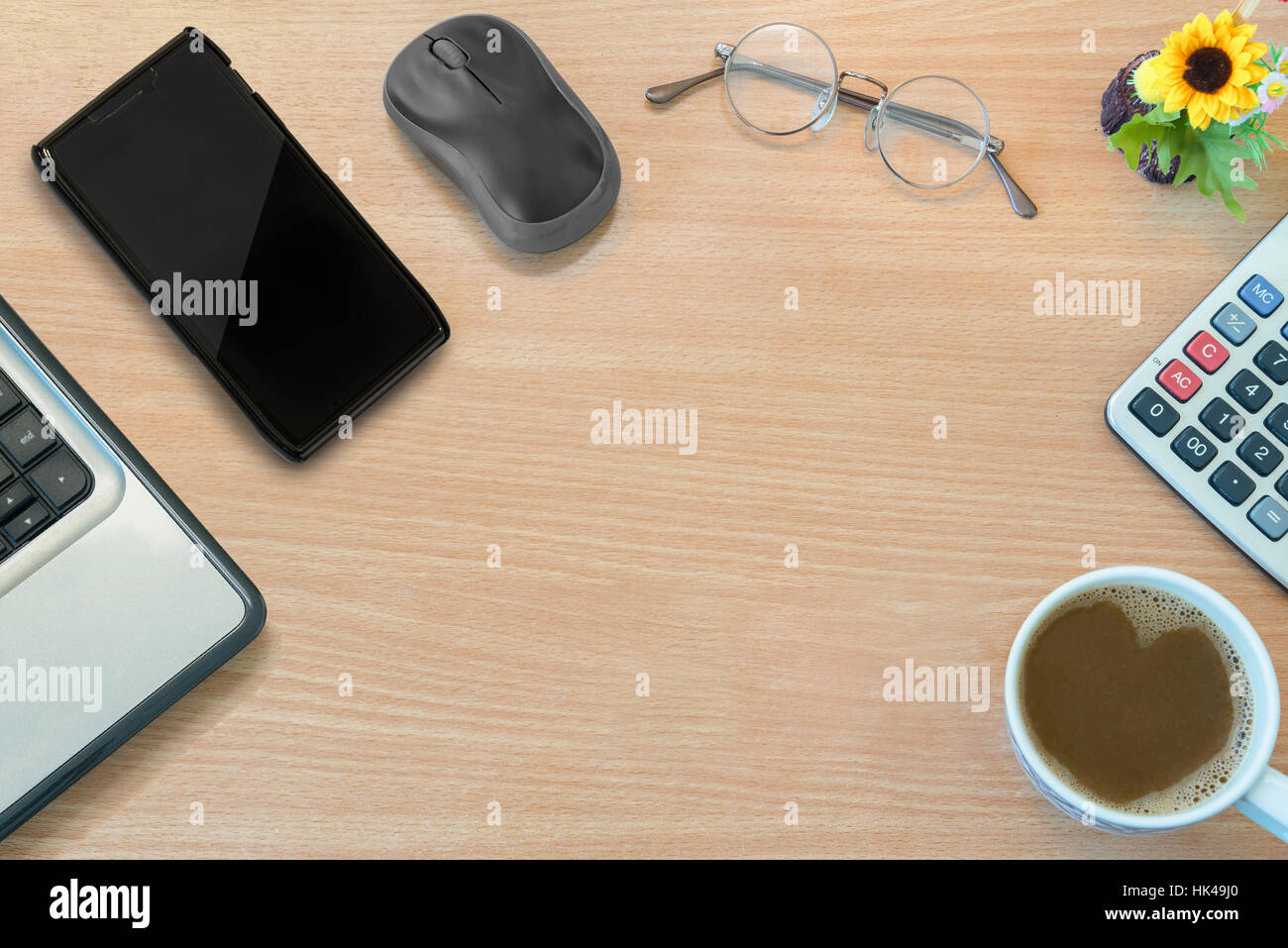 Top View Of Business Office Wood Desktop With Laptop/PC, Mobile Phone, Mouse, Glasses, Flower, Calculator And Cup Of Coffee Stock Photo