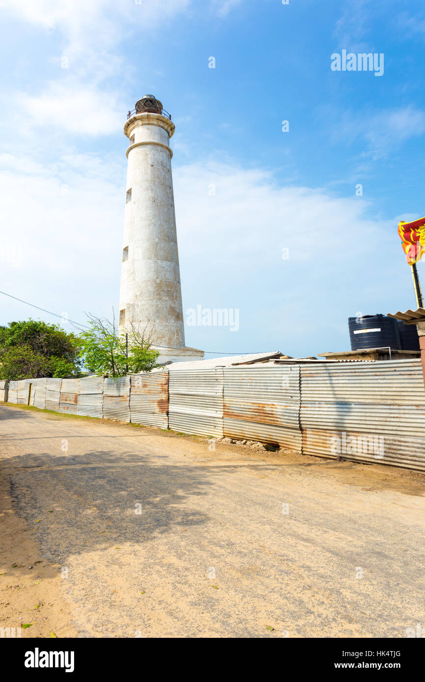 A rural road runs alongside the Point Pedro Lighthouse, now occupied by the military on the northern coast of Jaffna, Sri Lanka Stock Photo