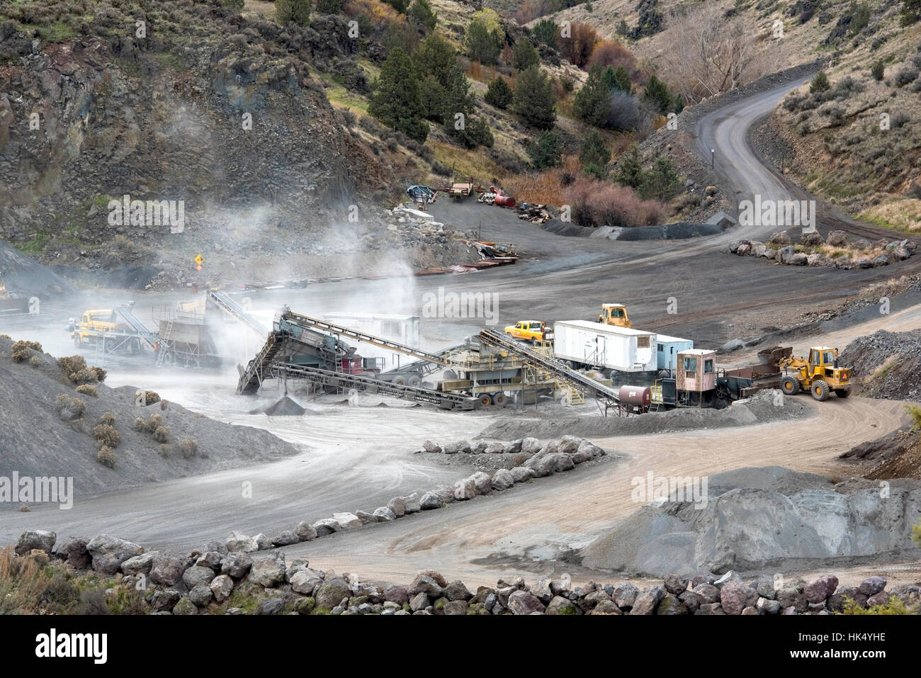 Rock Quarry with Conveyors, Rock Crusher and Heavy Equipment in a Canyon Stock Photo