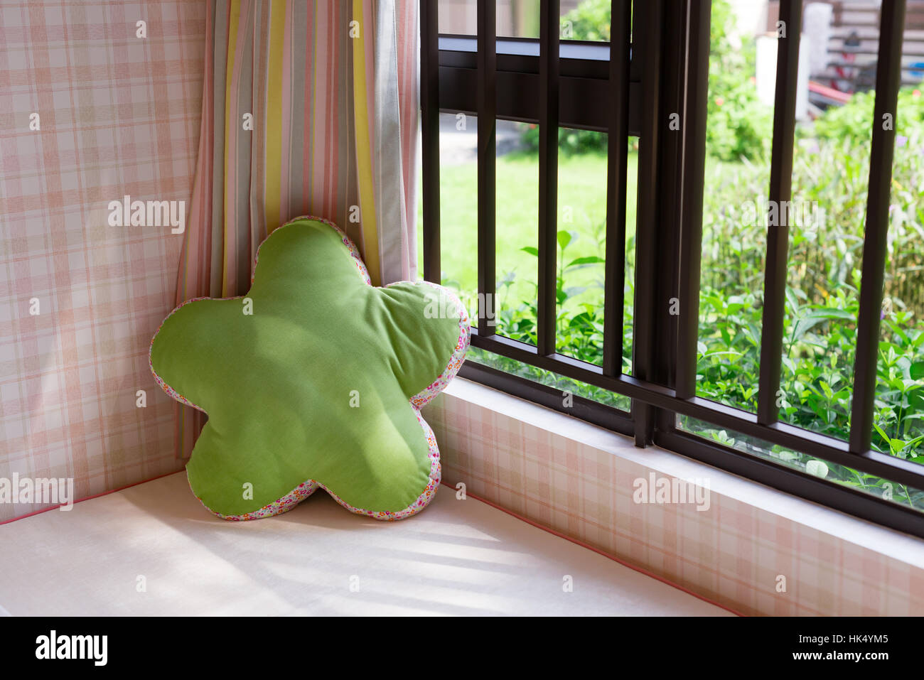 resting area of a cozy window seat with green cushion in the morning horizontal composition Stock Photo