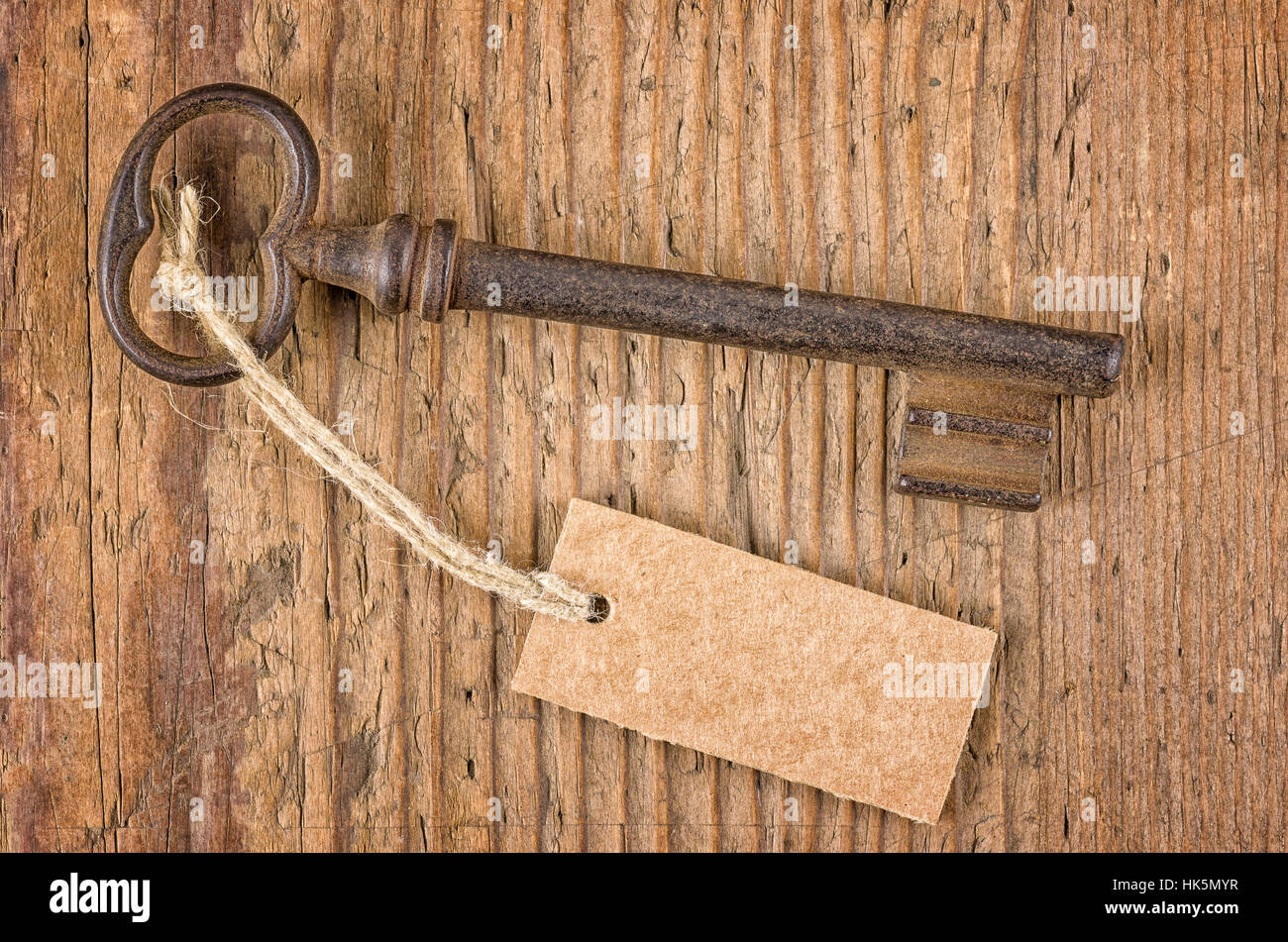 old key with pendant on a wooden board Stock Photo