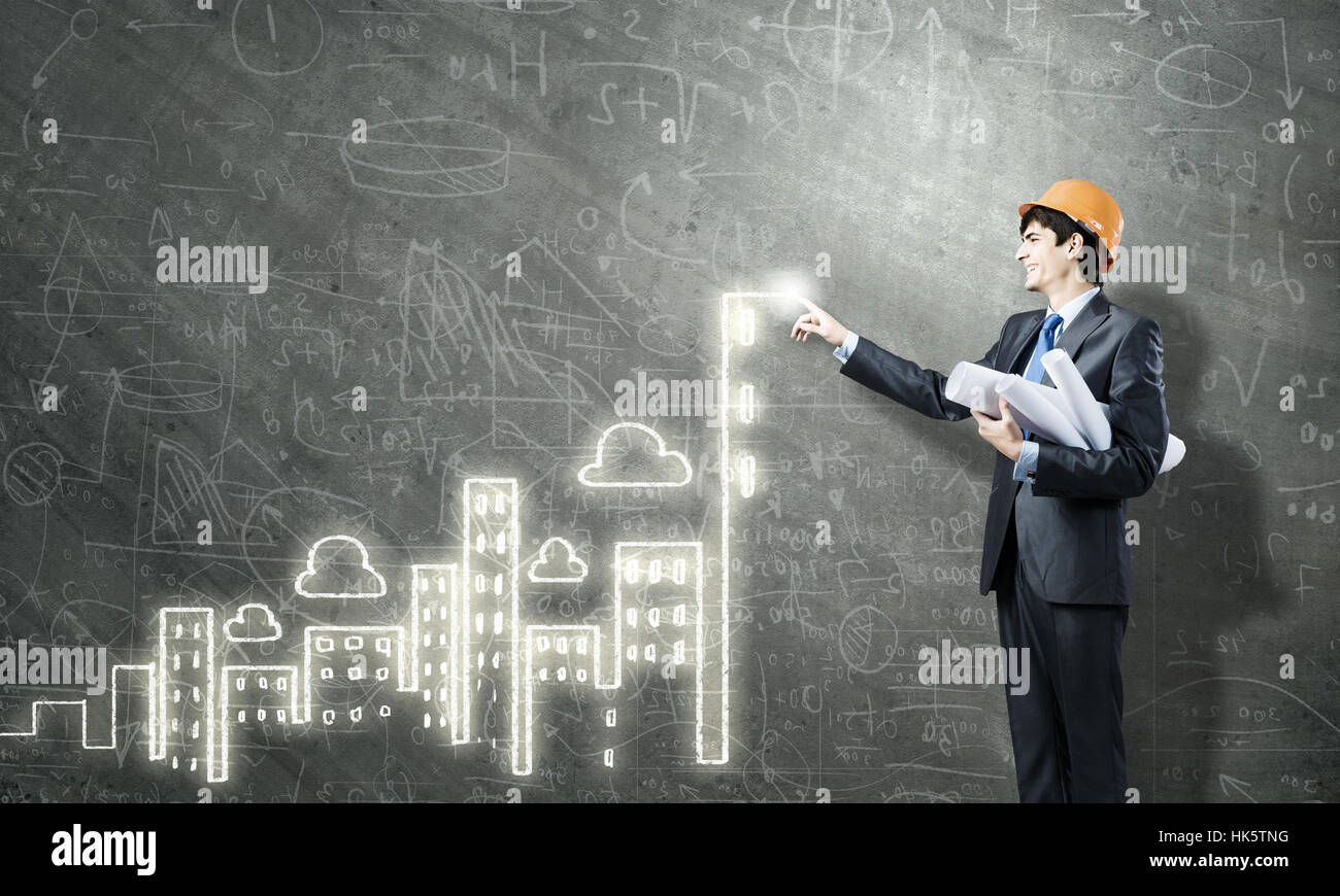 Young man engineer in helmet drawing construction project Stock Photo ...