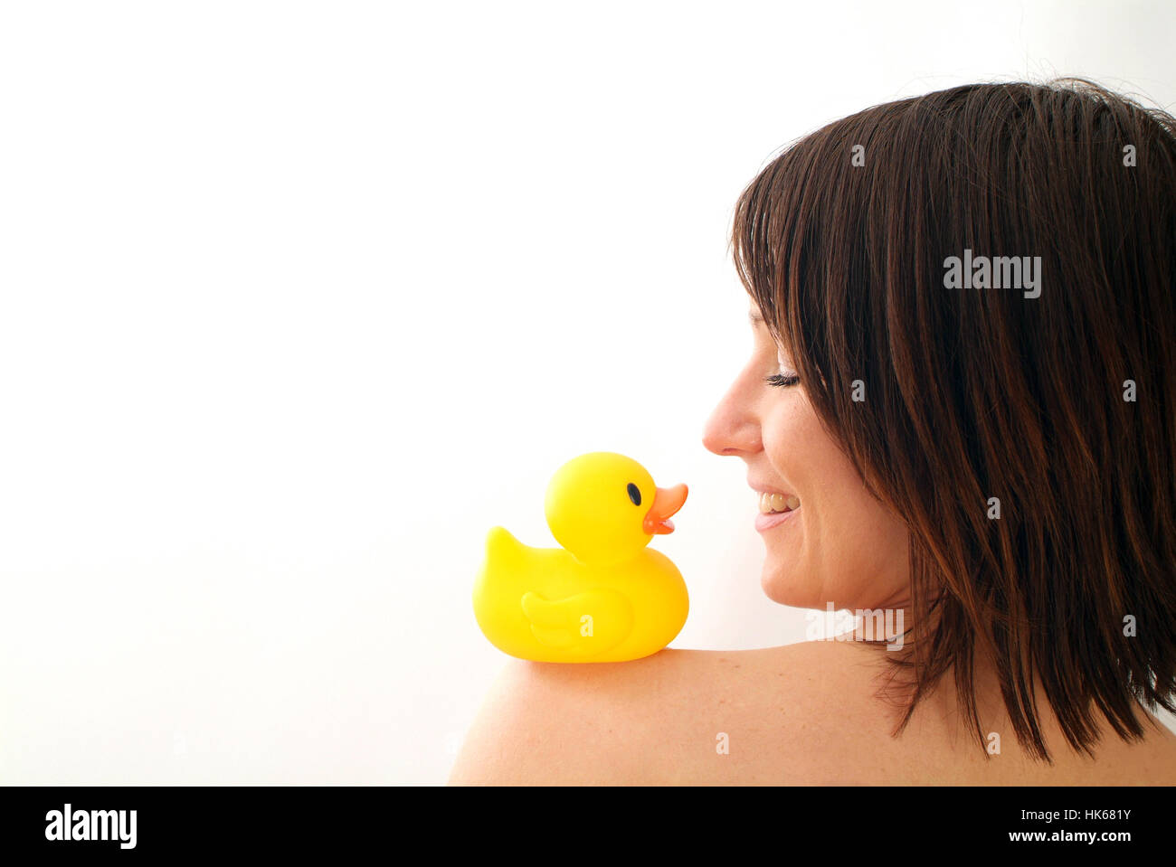 Young woman with rubber duck on shoulder Stock Photo