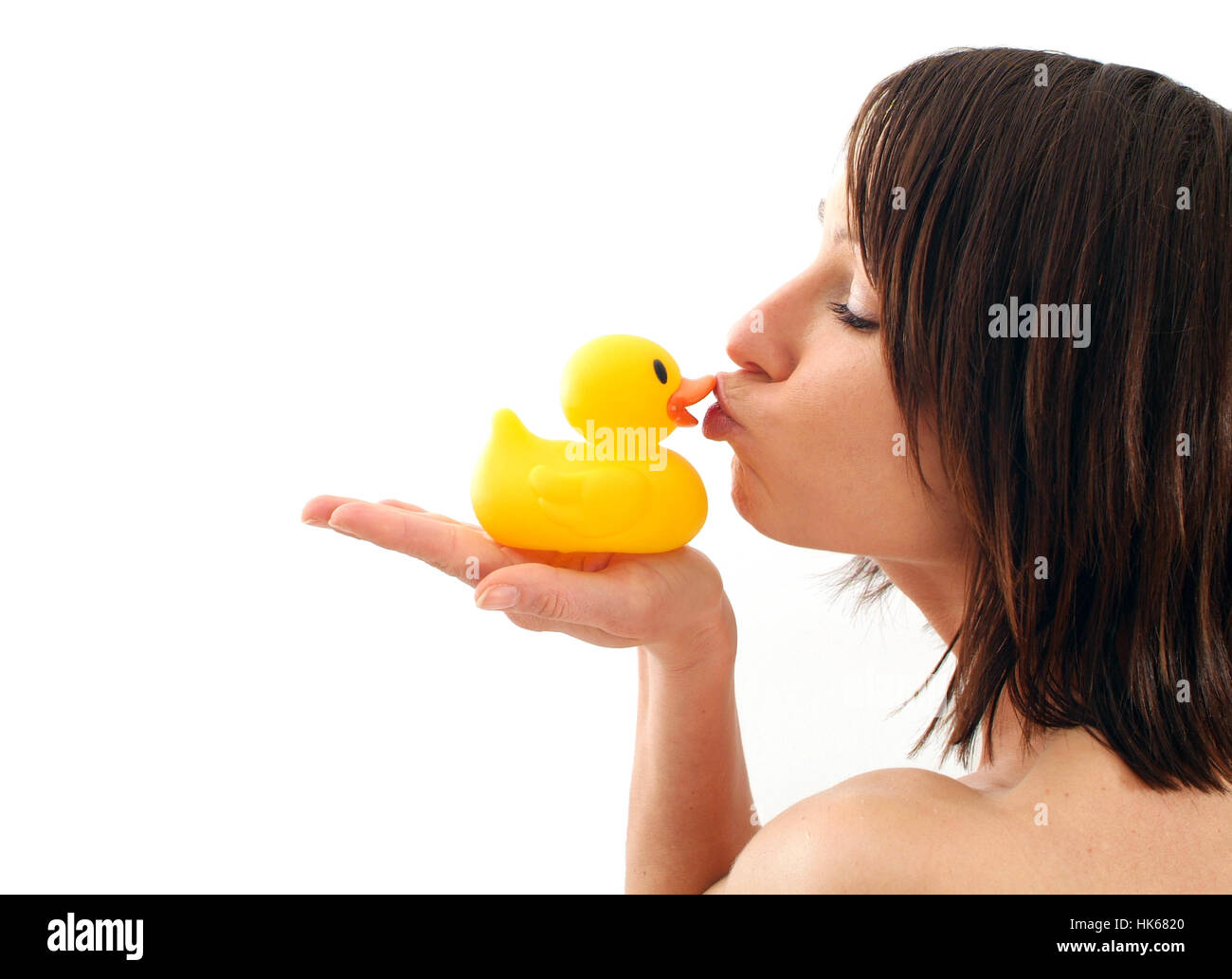 Young woman kissing rubber duck Stock Photo