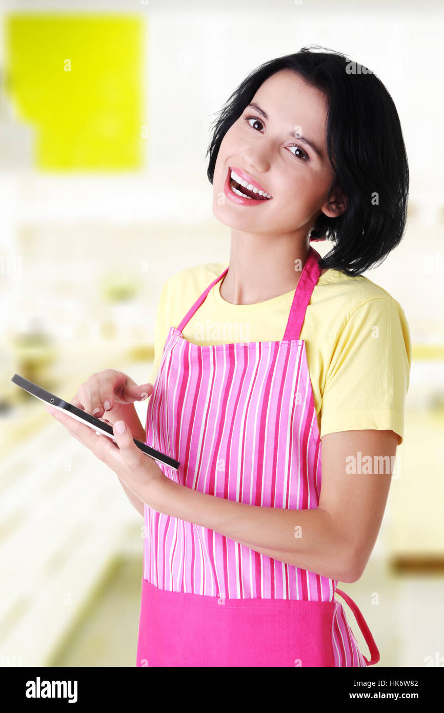 young woman in apron using tablet computer Stock Photo - Alamy