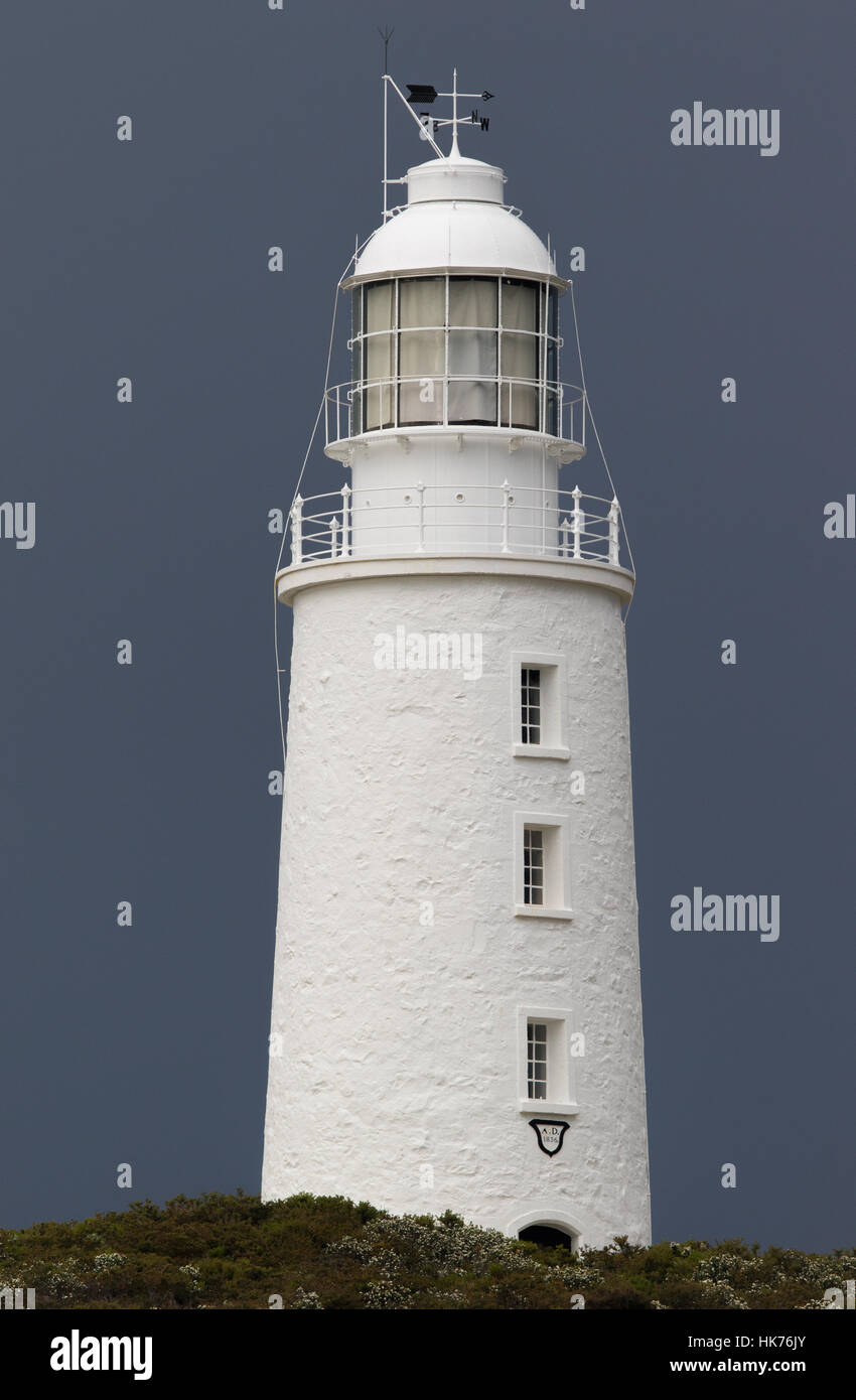 white building of Cape Bruny Lighthouse contrasting against background of dark storm clouds Stock Photo