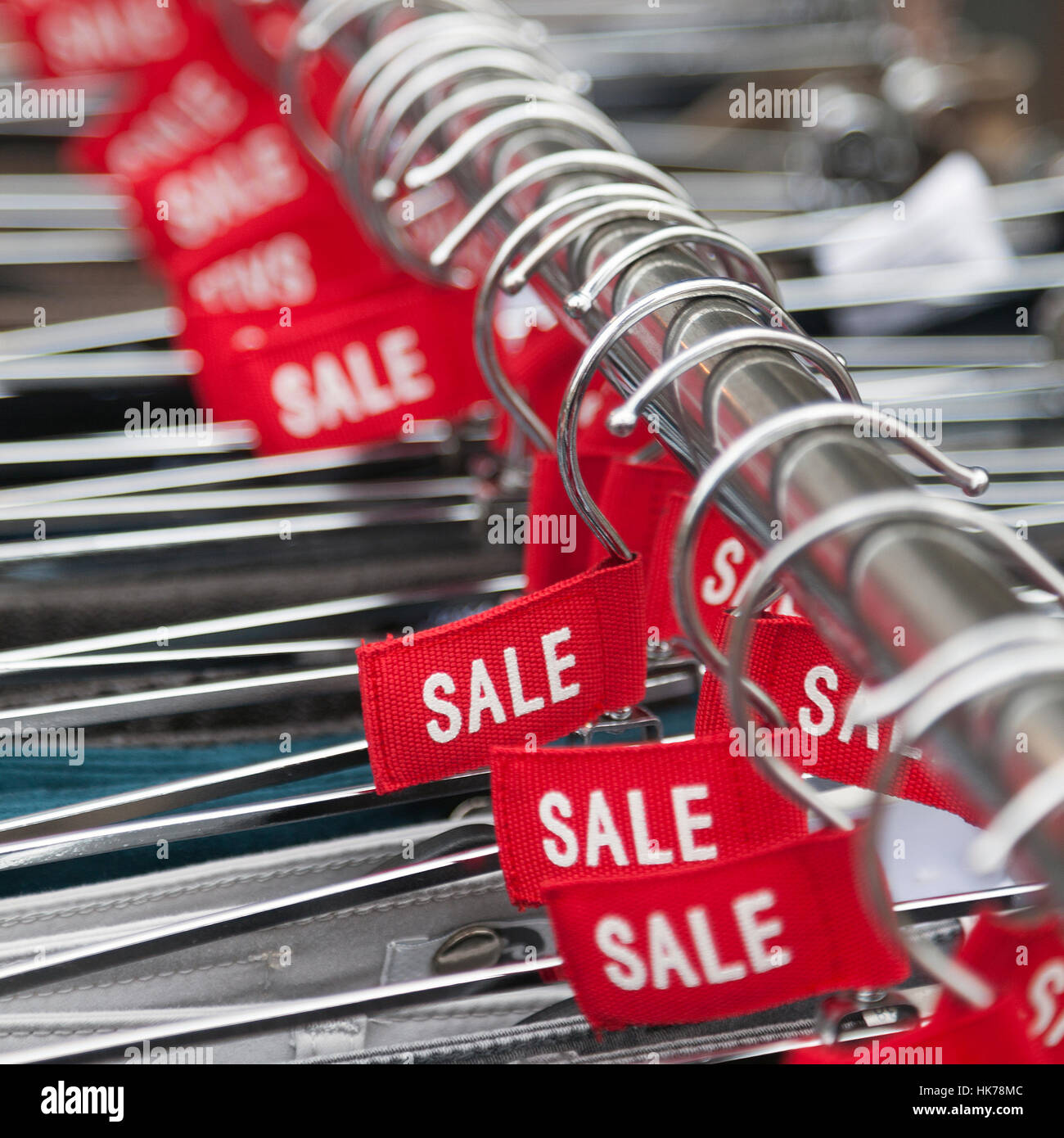 red labels with the word sale on clothes hangers outside fashion store