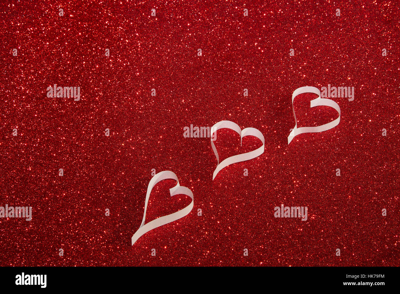 Three white paper hearts from paper on red shining background Stock ...