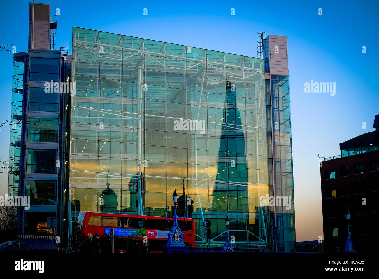 The Tower of London and The Shard are reflected off of the side of a glass office block at sunset. Stock Photo