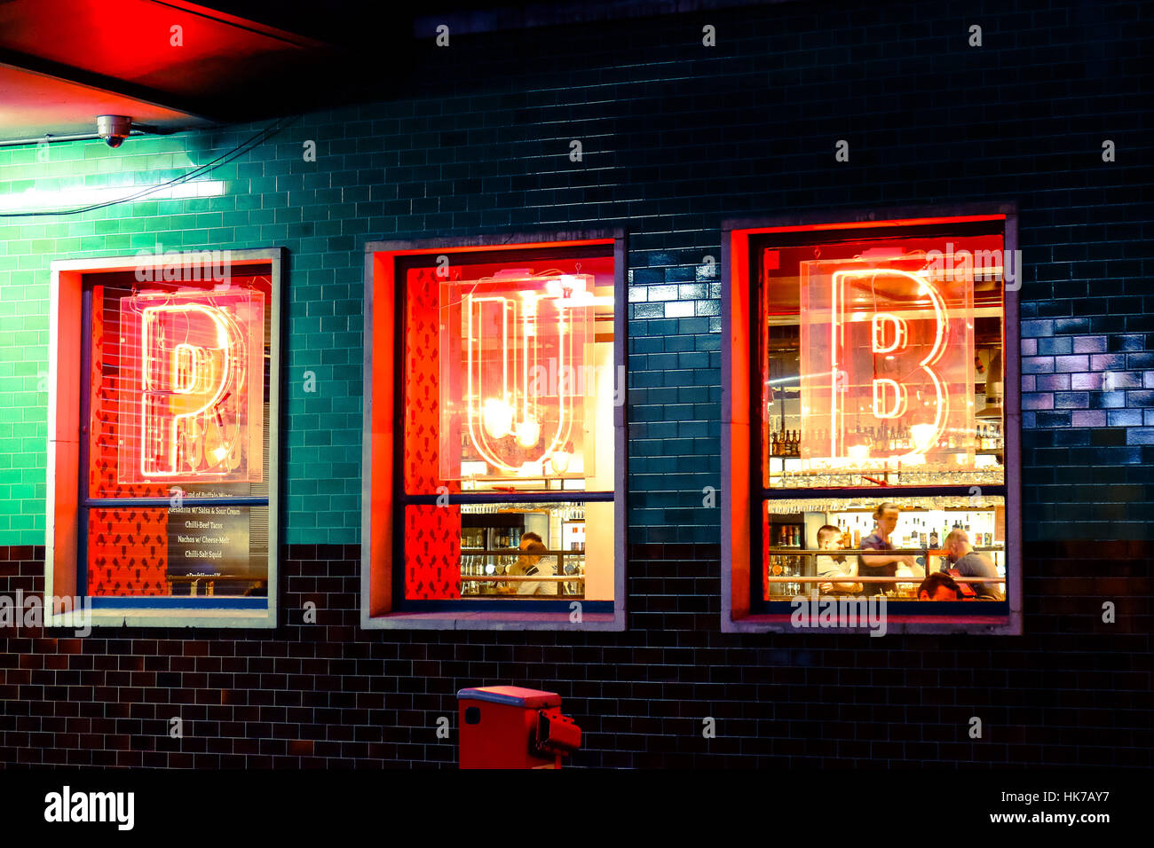 Neon signs shine in the windows of a bar Stock Photo