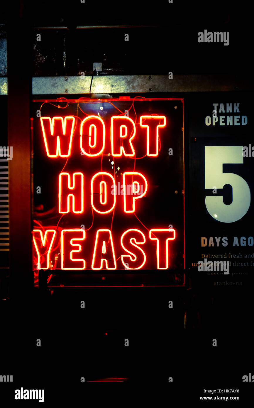A neon sign for craft beer hangs in an urban bar Stock Photo