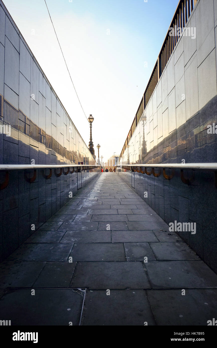 Walkway ascending onto street level in an urban environment. Stock Photo