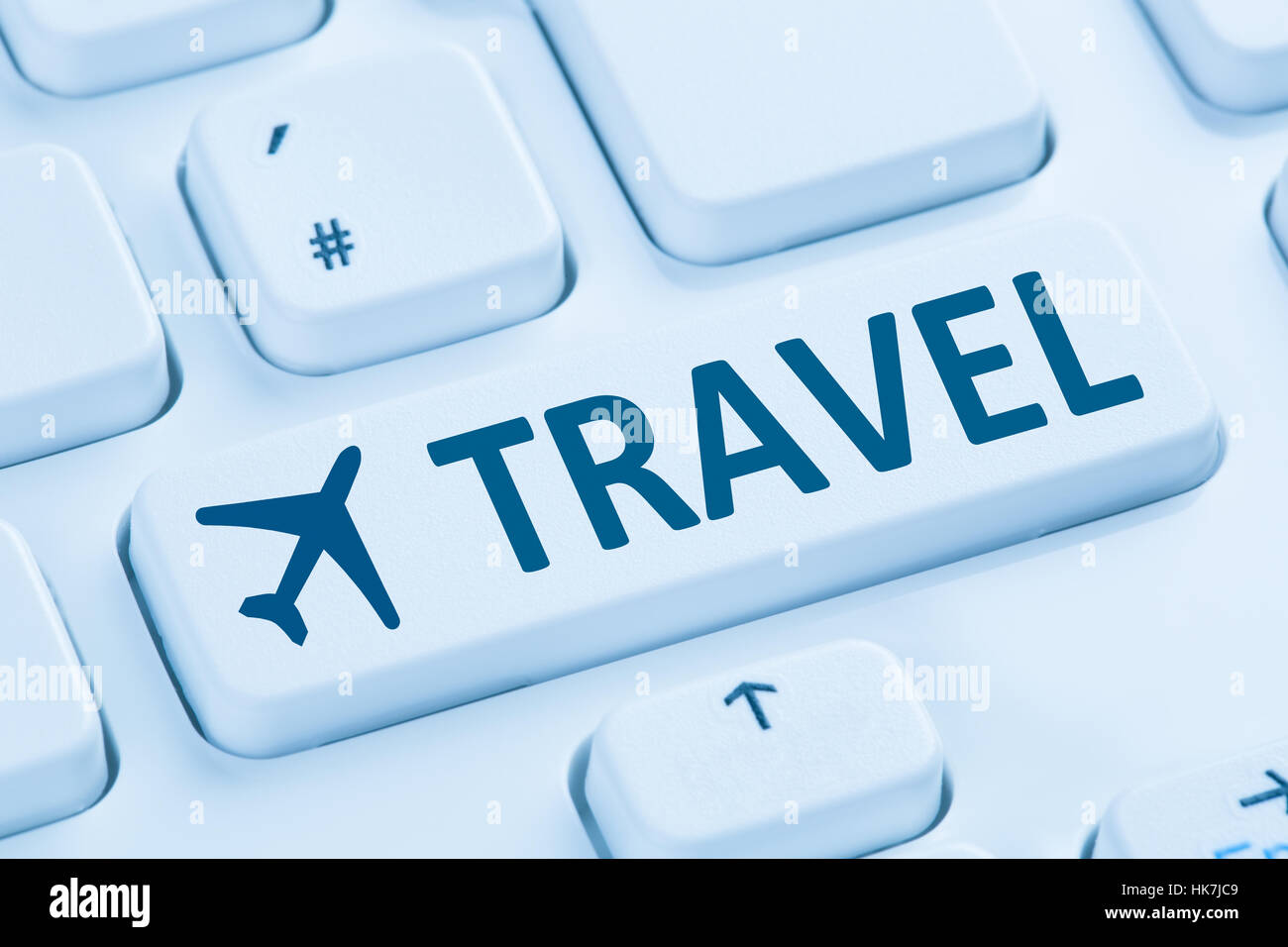 Booking flight holidays vacation travel online shop internet symbol blue computer keyboard Stock Photo