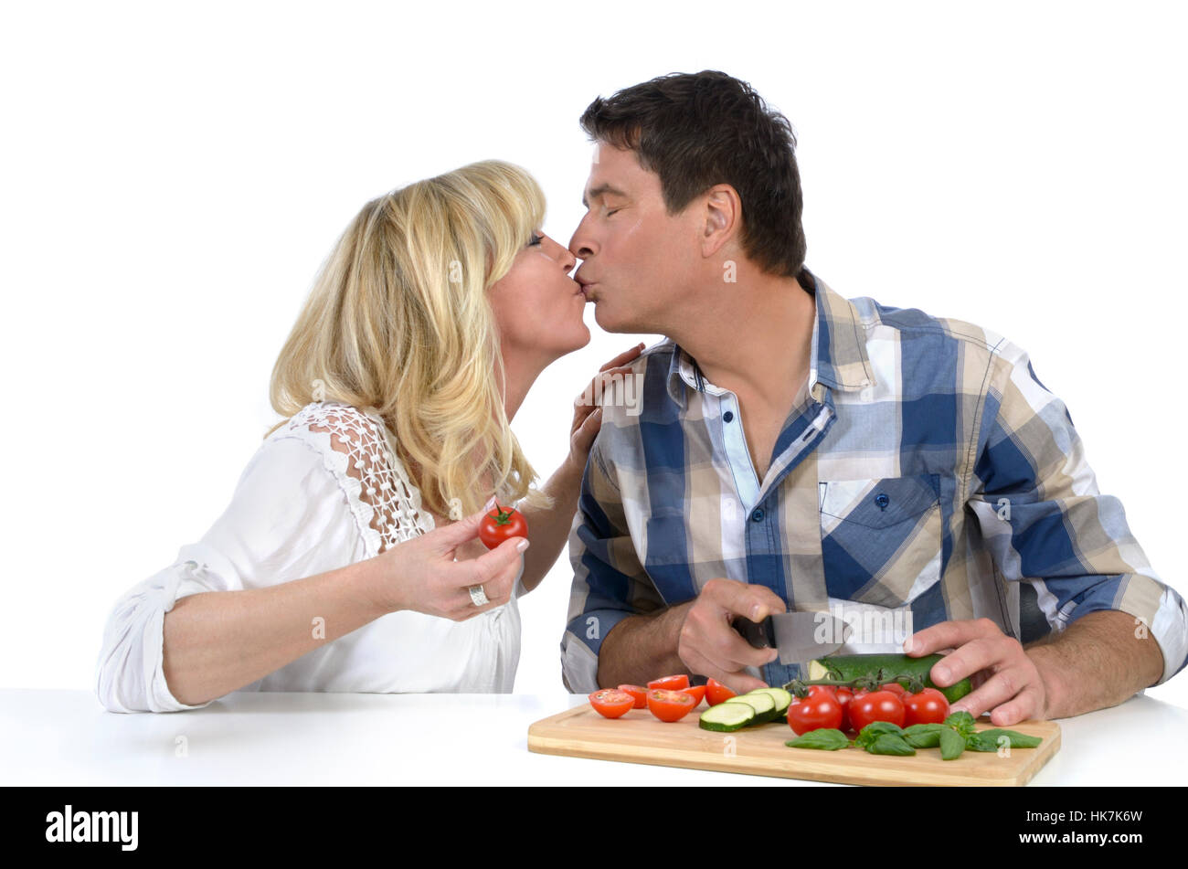 happy mature couple kissing while cooking Stock Photo - Alamy