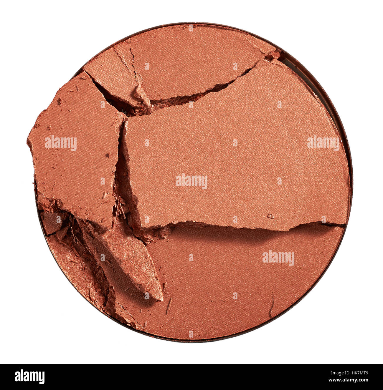 A beauty cut-out image of a sample make up powder. A broken circle-shaped compact of flesh, brown or tan coloured make-up or bronzer. Stock Photo