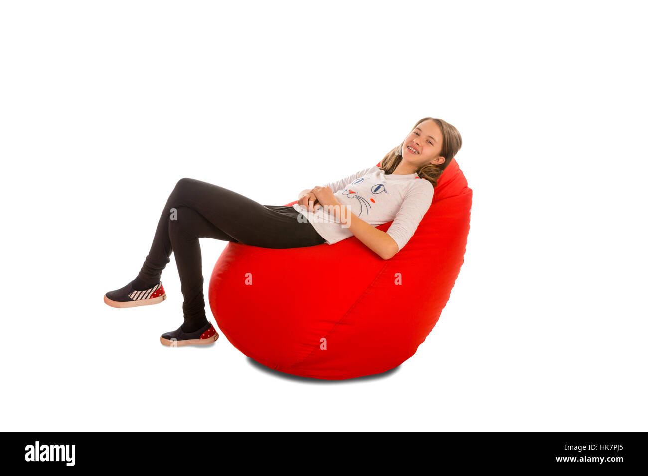 Young Girl Sitting On Red Beanbag Chair Isolated On White