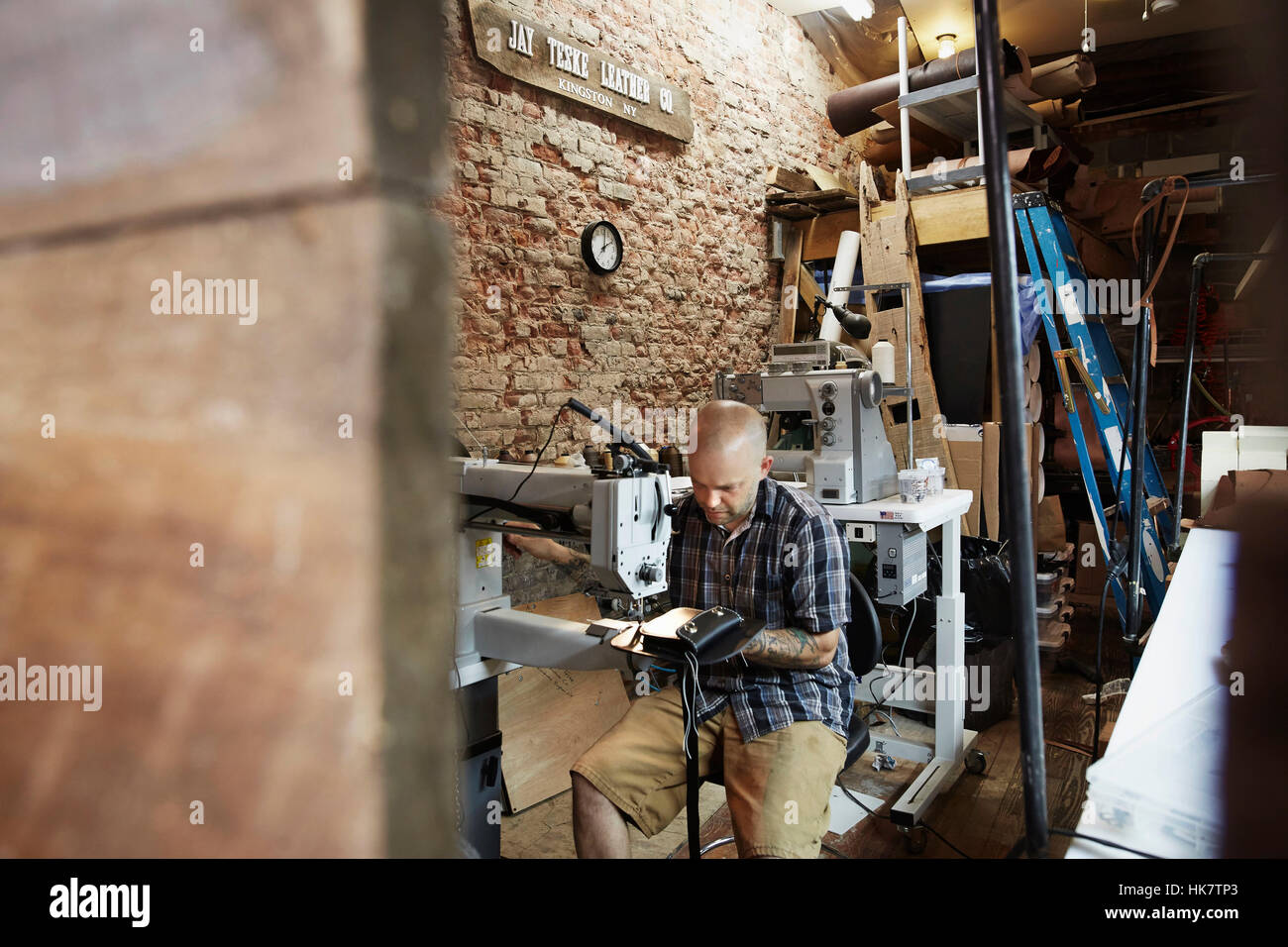 A leather worker, craftsman using an industrial sewing machine on
