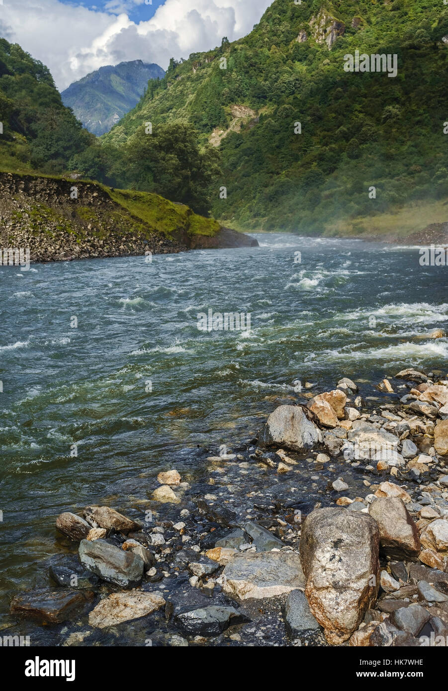 Kameng river snakes between forested slopes of the Himalaya mountains with view of the river bank in the monsoon season. Stock Photo