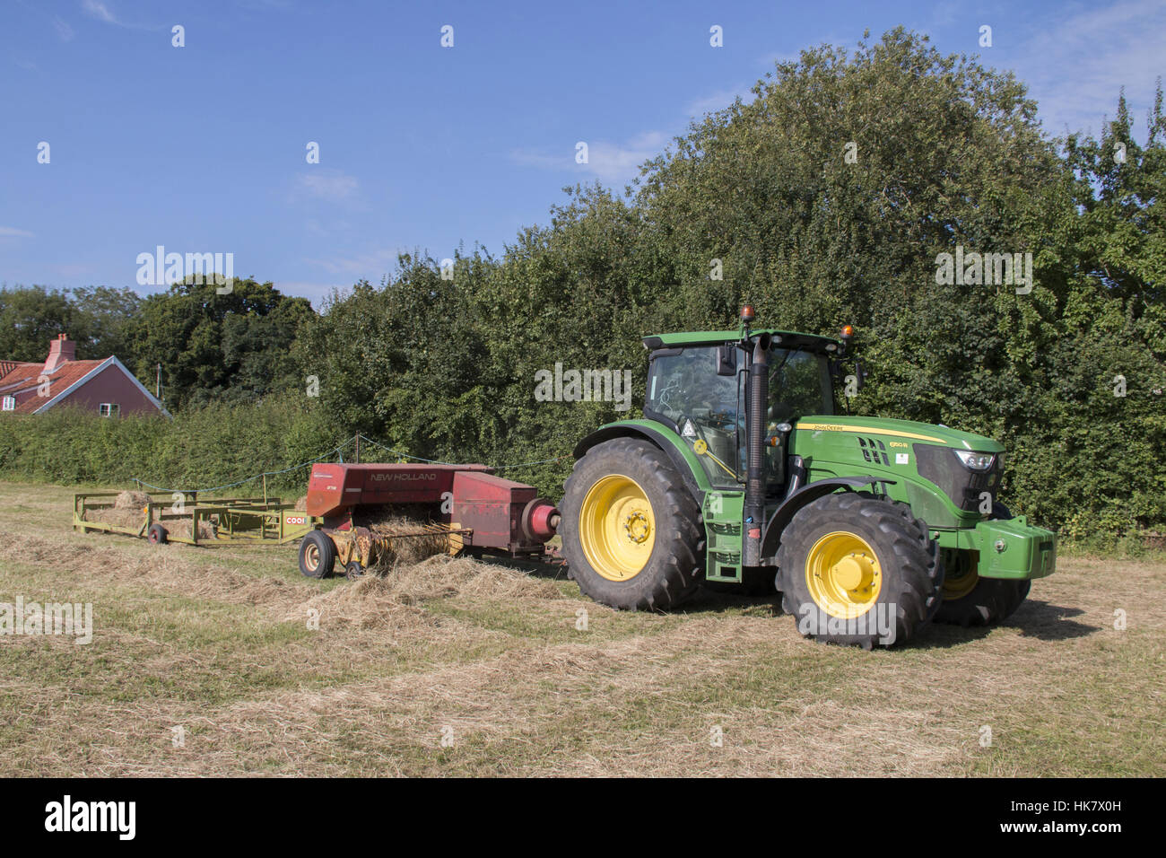 Haymaking, third stage, tractor towing conventional baler and bale