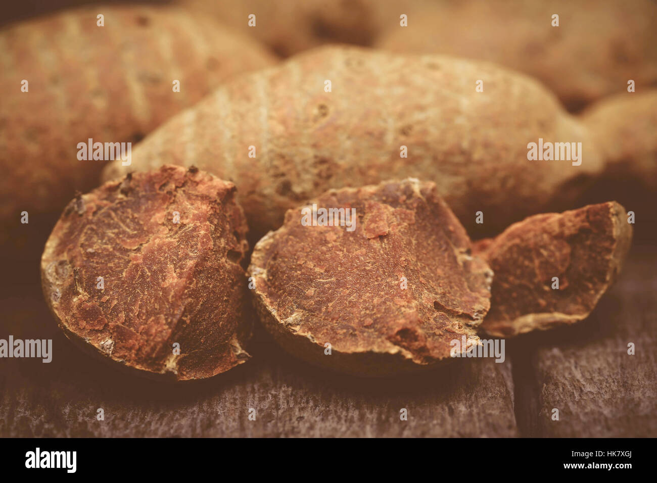 Whole with pieces of turmeric on wooden surface Stock Photo