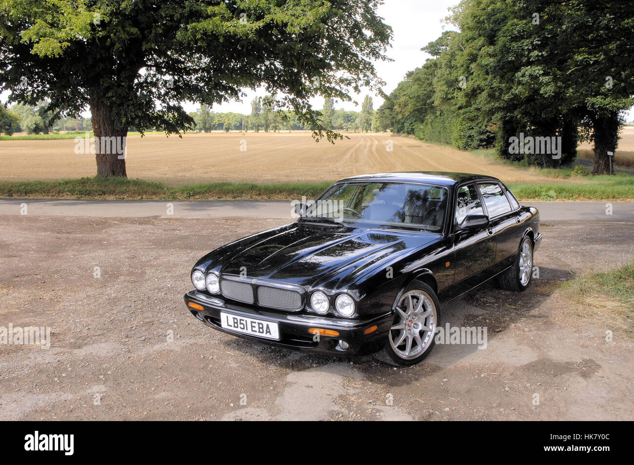Jaguar XJR100 black car parked with trees Stock Photo