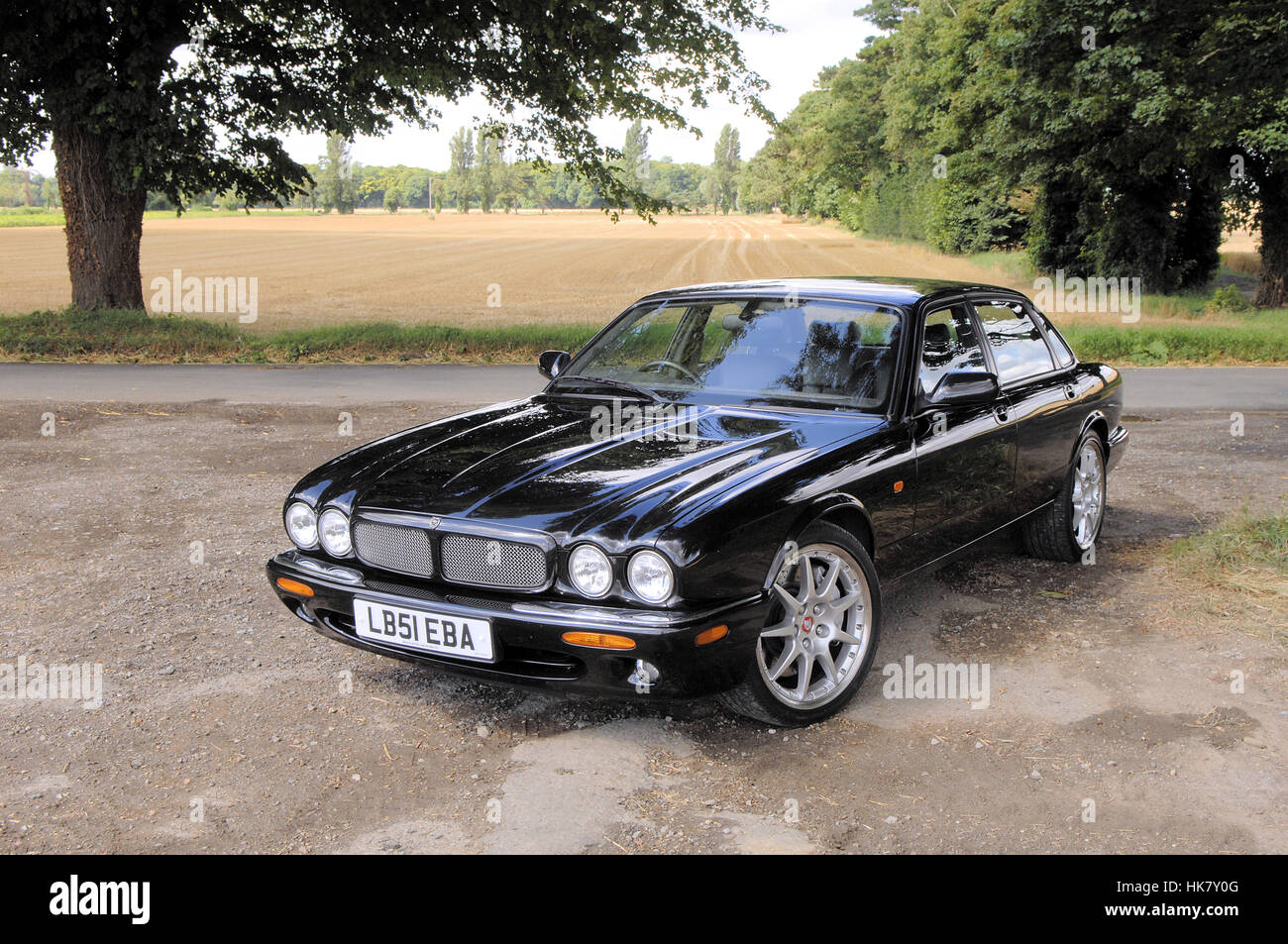 Jaguar XJR100 black car parked with trees Stock Photo