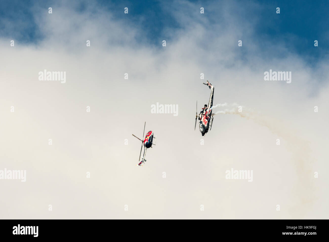 Two helicopters are performing stunts in the air Stock Photo