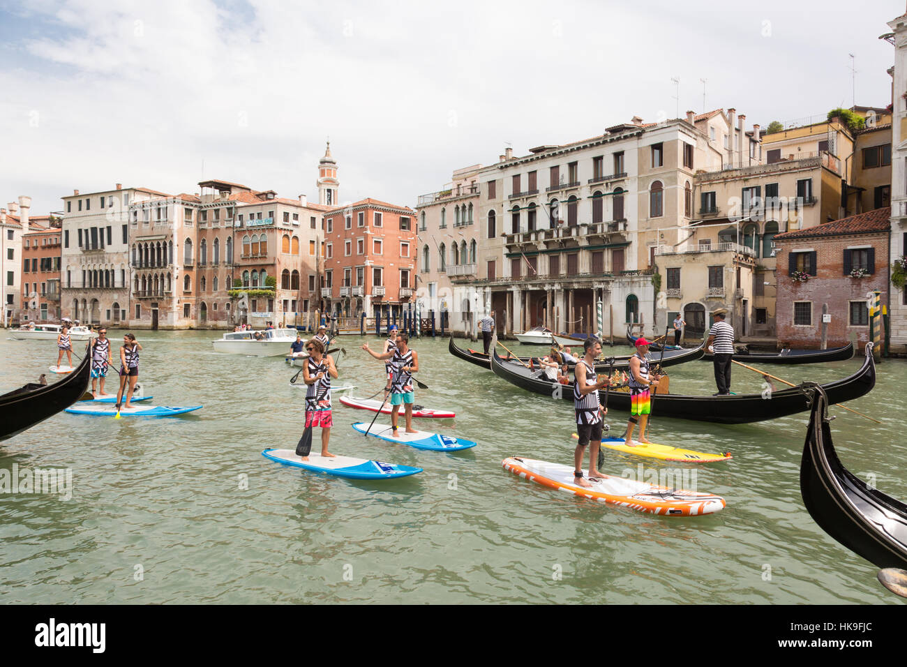 Group of active tourists stand up paddling on sup boards at Grand Canal, Venice, Italy. Stock Photo