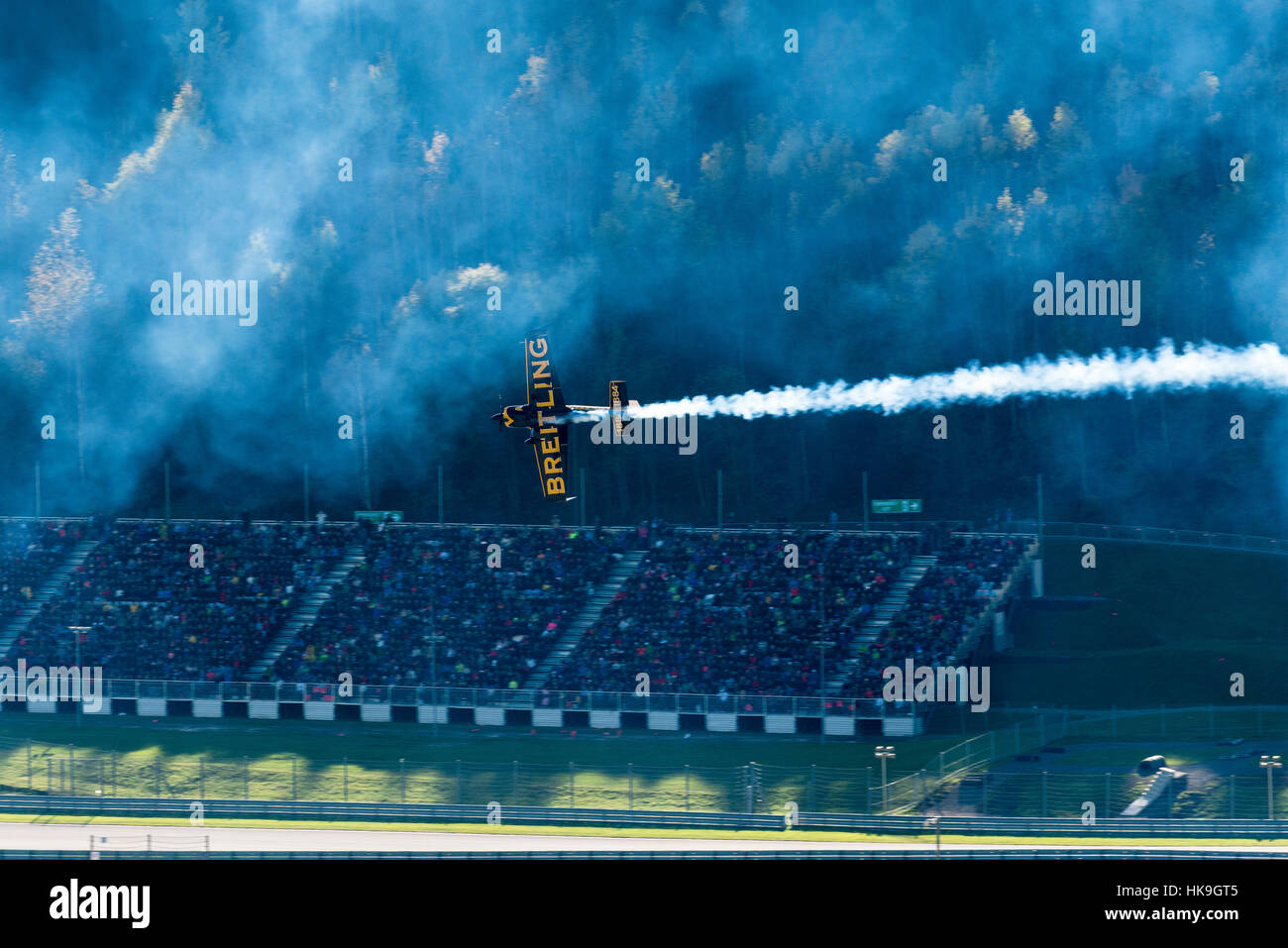 A stunt flying aeroplane, releasing smoke, is flying vertically in ...