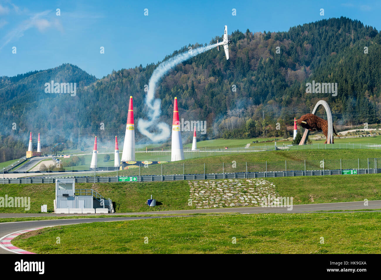 A stunt flying aeroplane, releasing smoke, is flying vertically through ...
