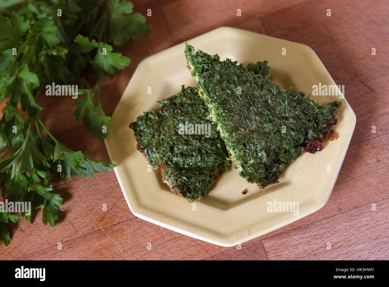 two slices of parsley cake on a cream coloured plate with fresh parsley HK9HWY