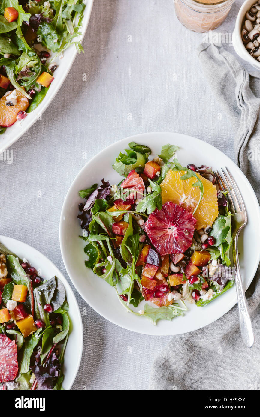 Bowls of Citrusy Roasted Beet Goat Cheese Salad with Black Eyed Peas are photographed from the top Stock Photo