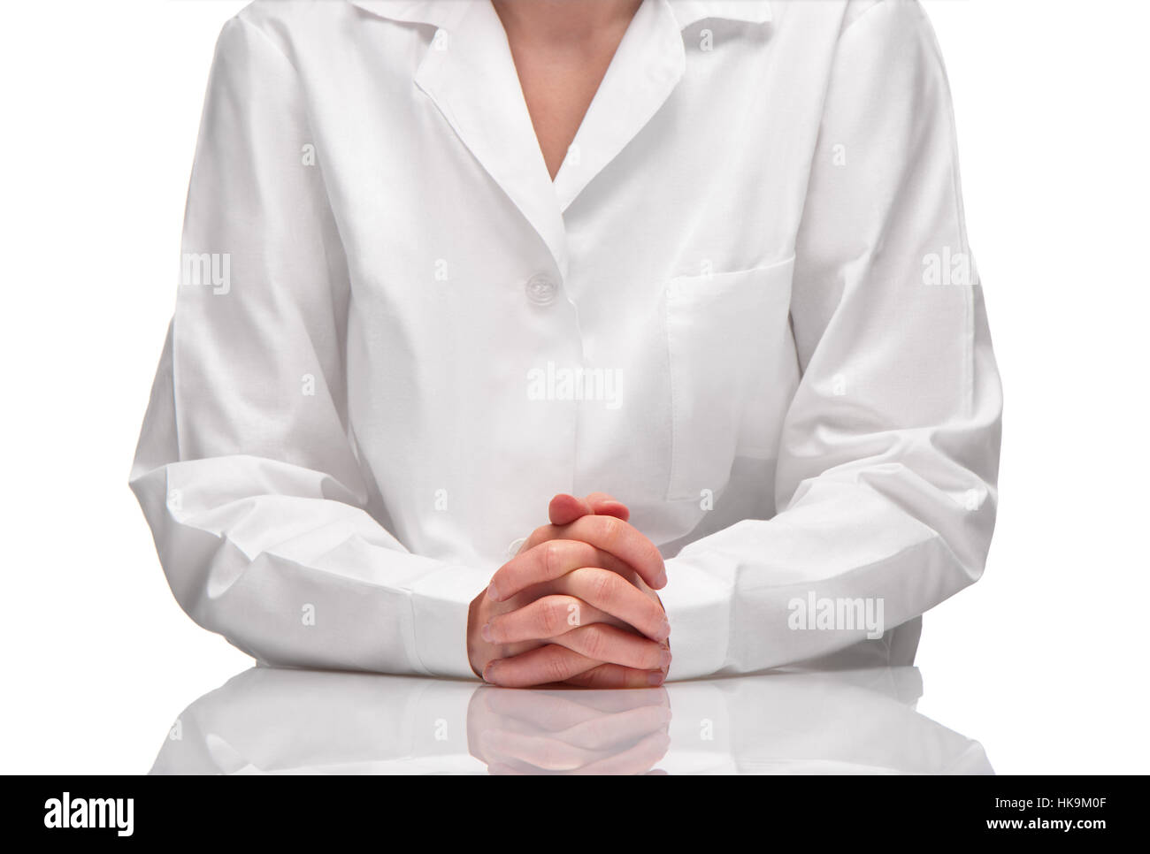 Close up of female in white gown sitting at table against white background Stock Photo