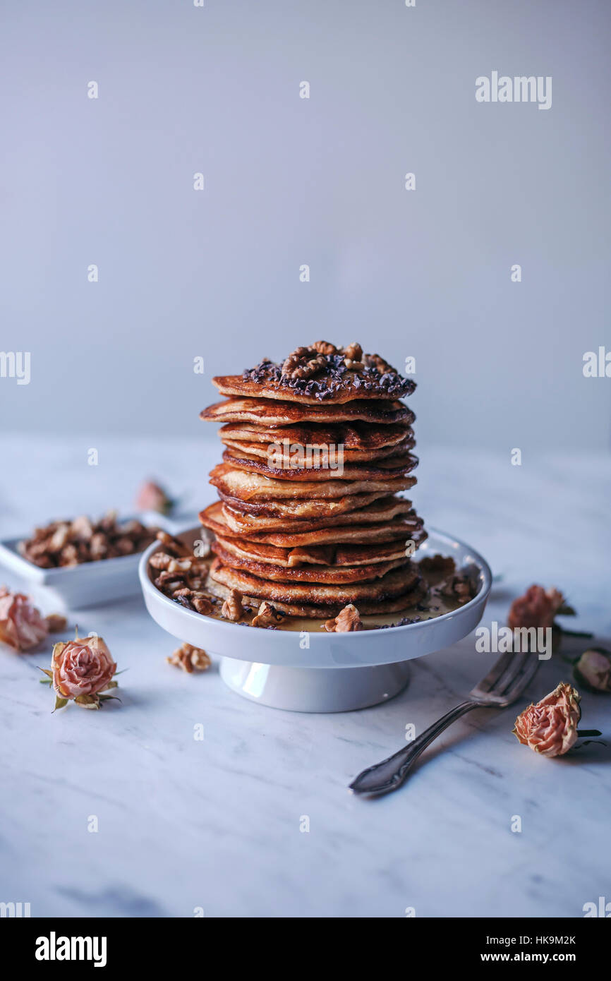 Stack of pancakes topped with maple syrup, walnuts and cacao nibs Stock Photo