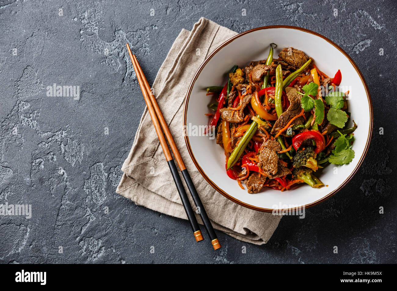 Stir fry beef with vegetables in bowl on dark stone background Stock Photo