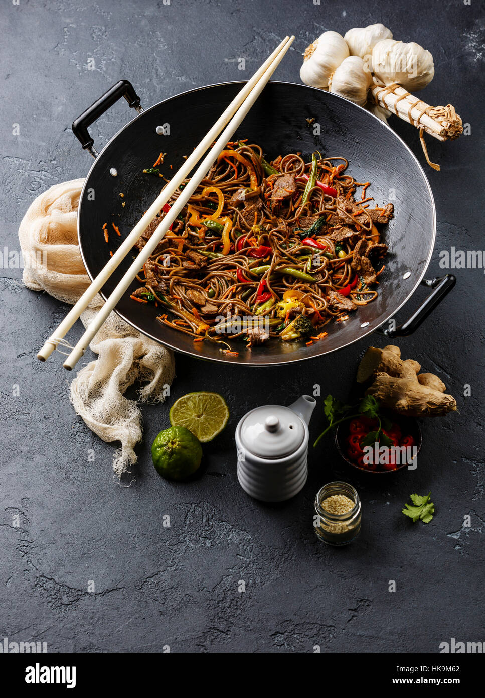 Asian fast food Stir fry noodles soba with beef and vegetables in wok pan  on dark stone background Stock Photo - Alamy