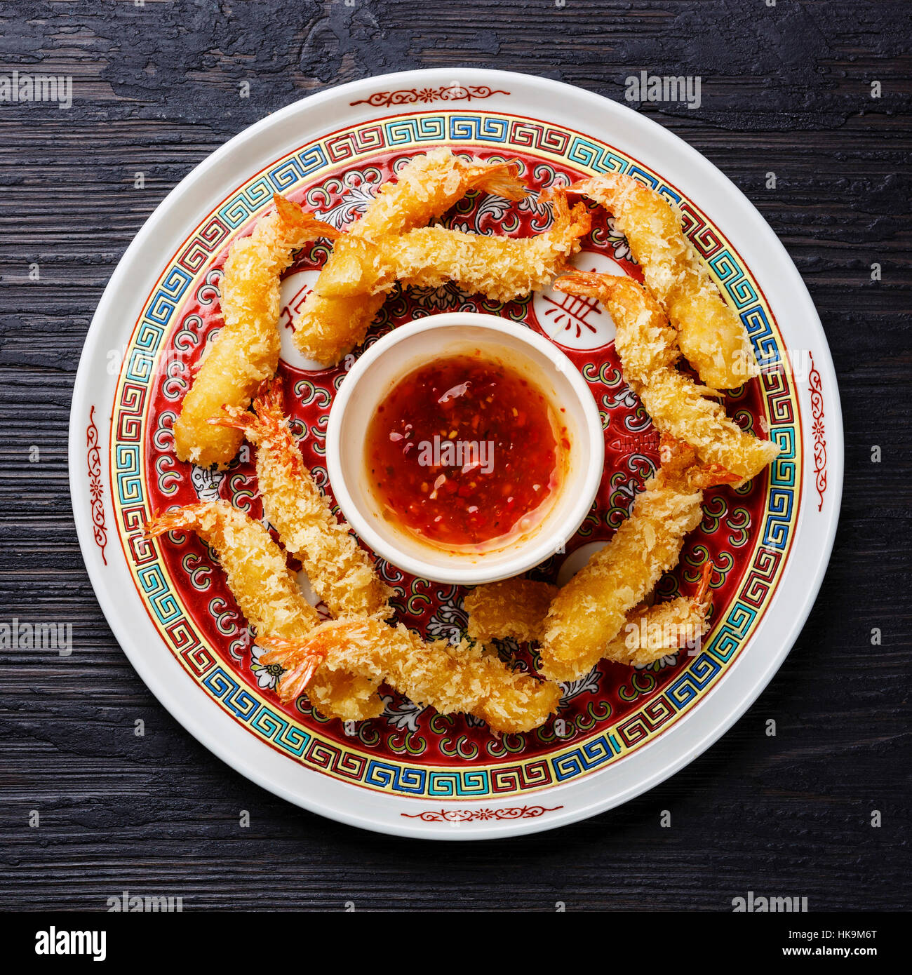 Deep fried breaded Tempura prawn shrimps with sauce on black burned wooden background Stock Photo