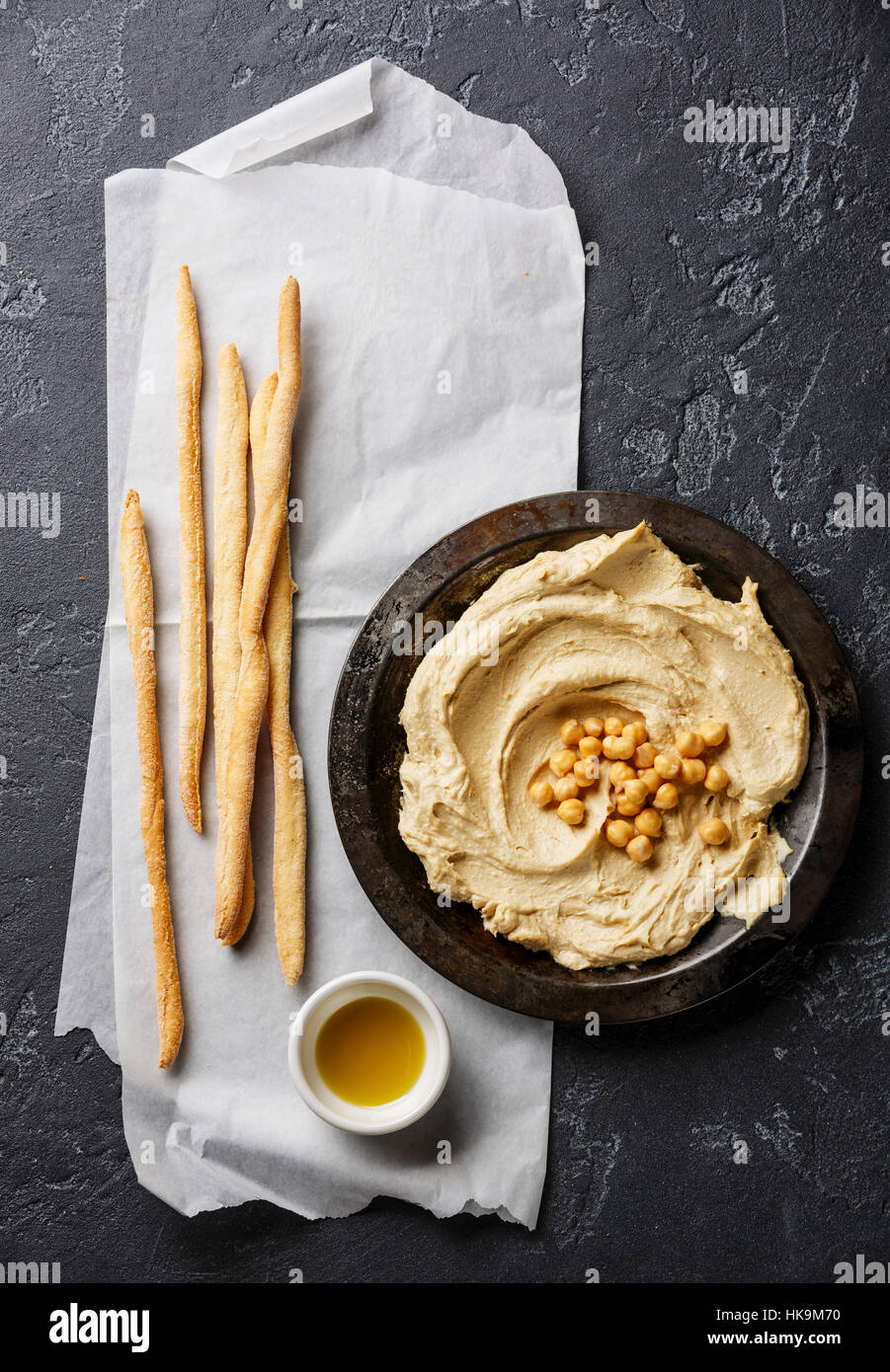 Homemade creamy hummus and Bread sticks on black stone background Stock Photo