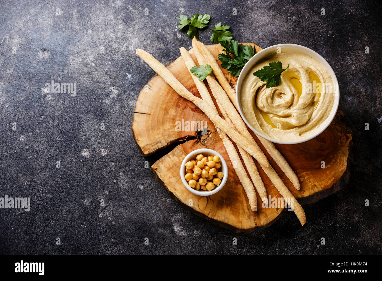 Homemade hummus with bread sticks and parsley on stone background copy space Stock Photo