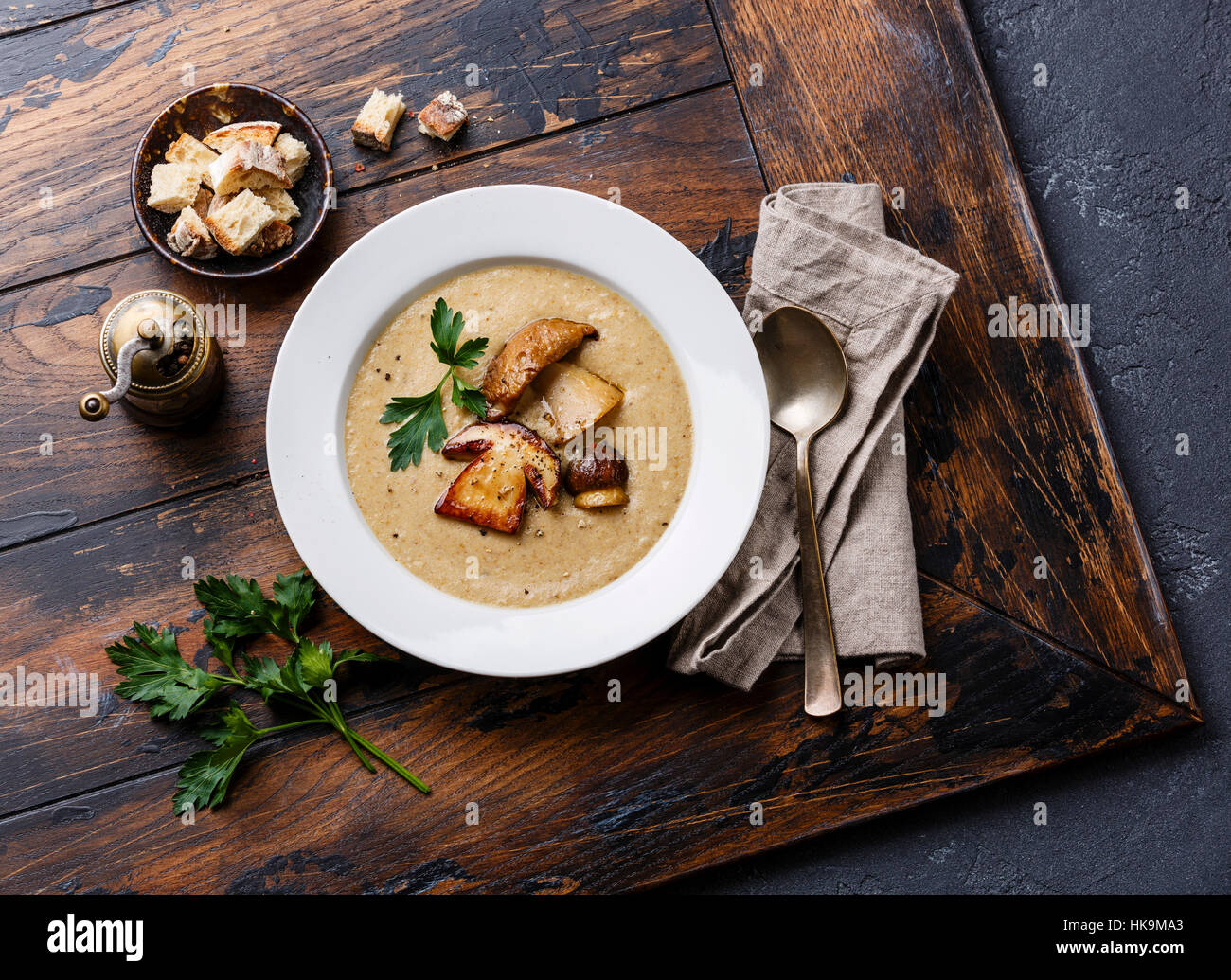 Cream-soup with porcini mushroom with croutons on wooden table Stock Photo