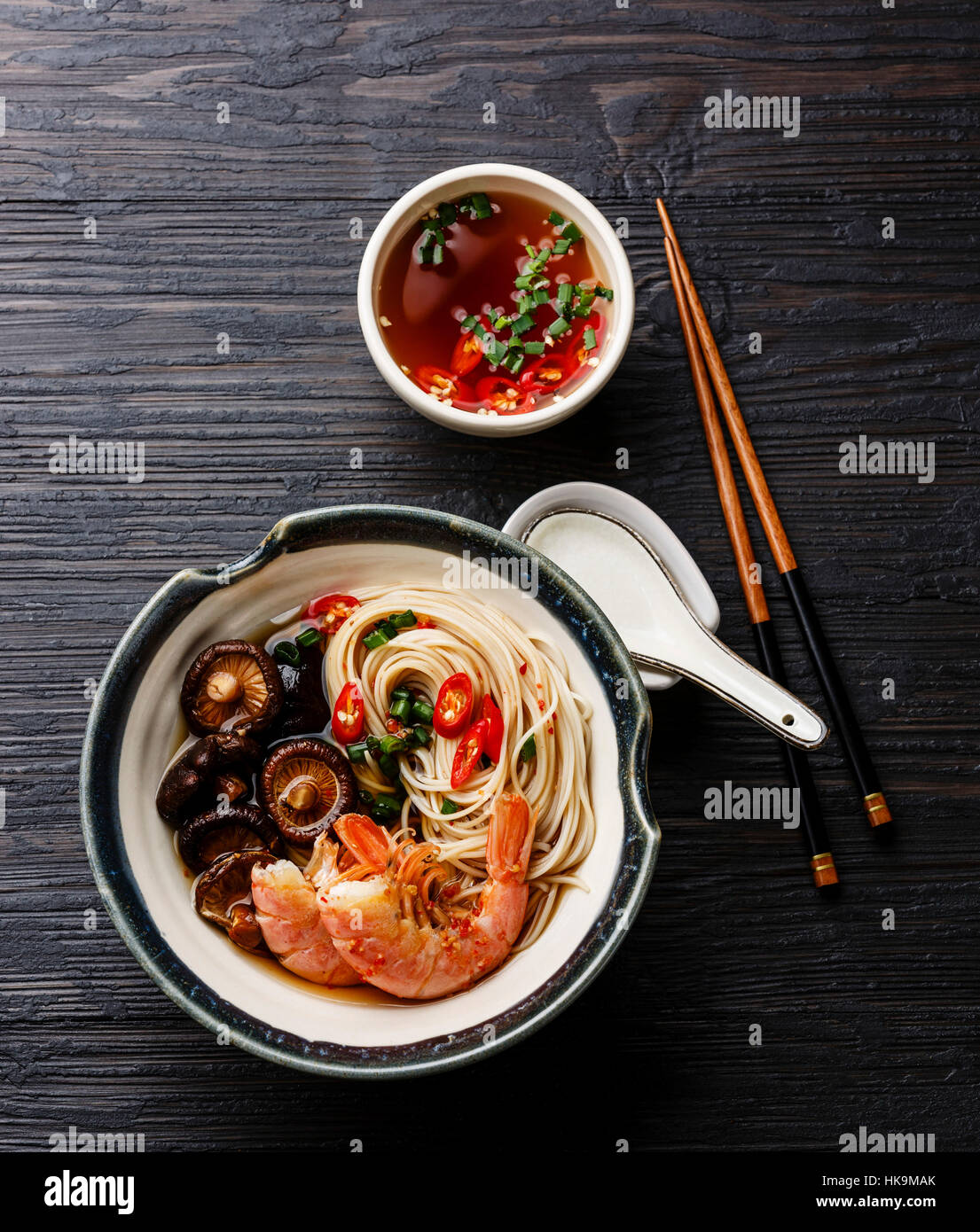 Ramen noodles with prawns and shiitake mushrooms with broth on dark wooden background Stock Photo
