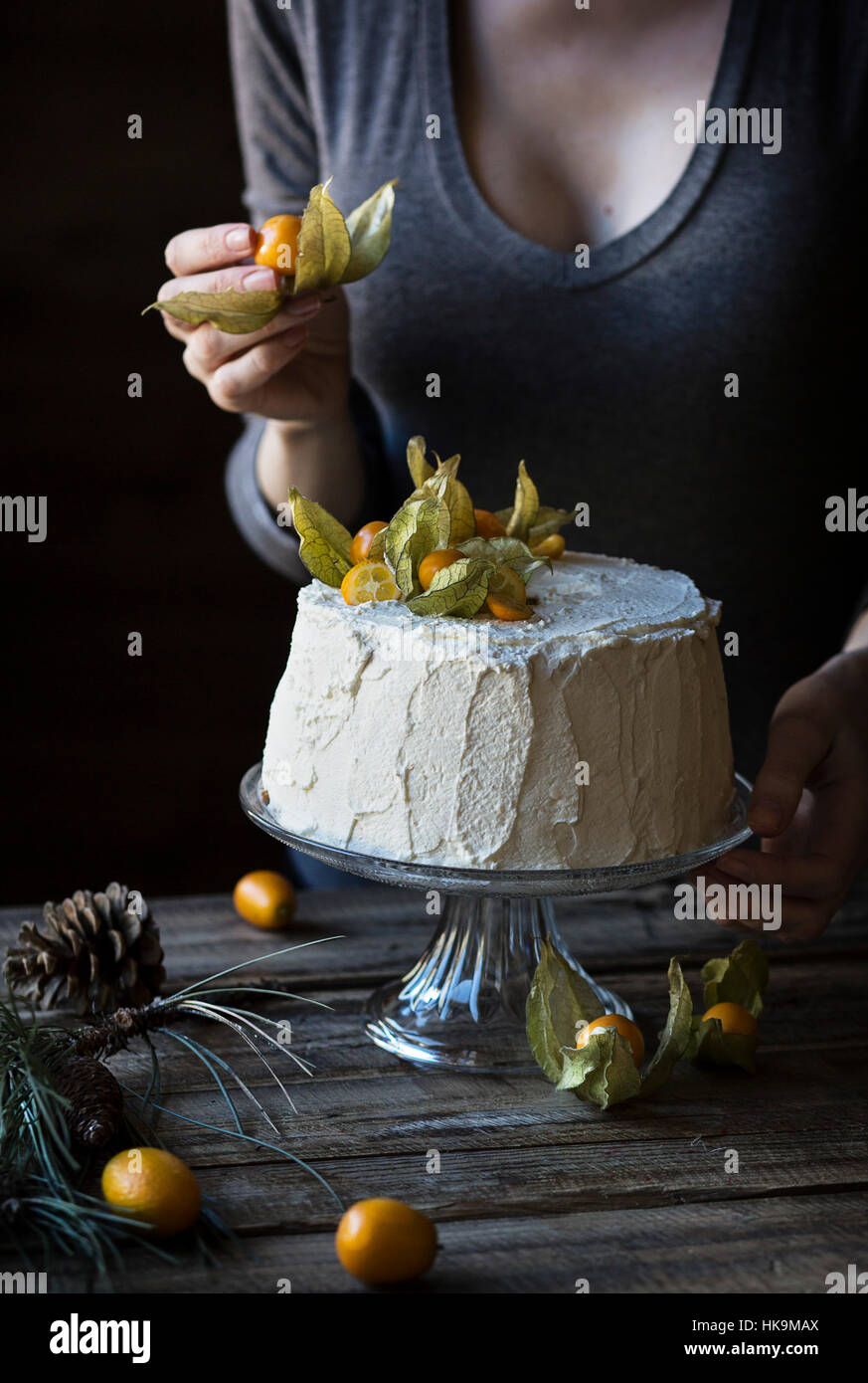 Woman is decorating a chiffon cake on wooden table Stock Photo