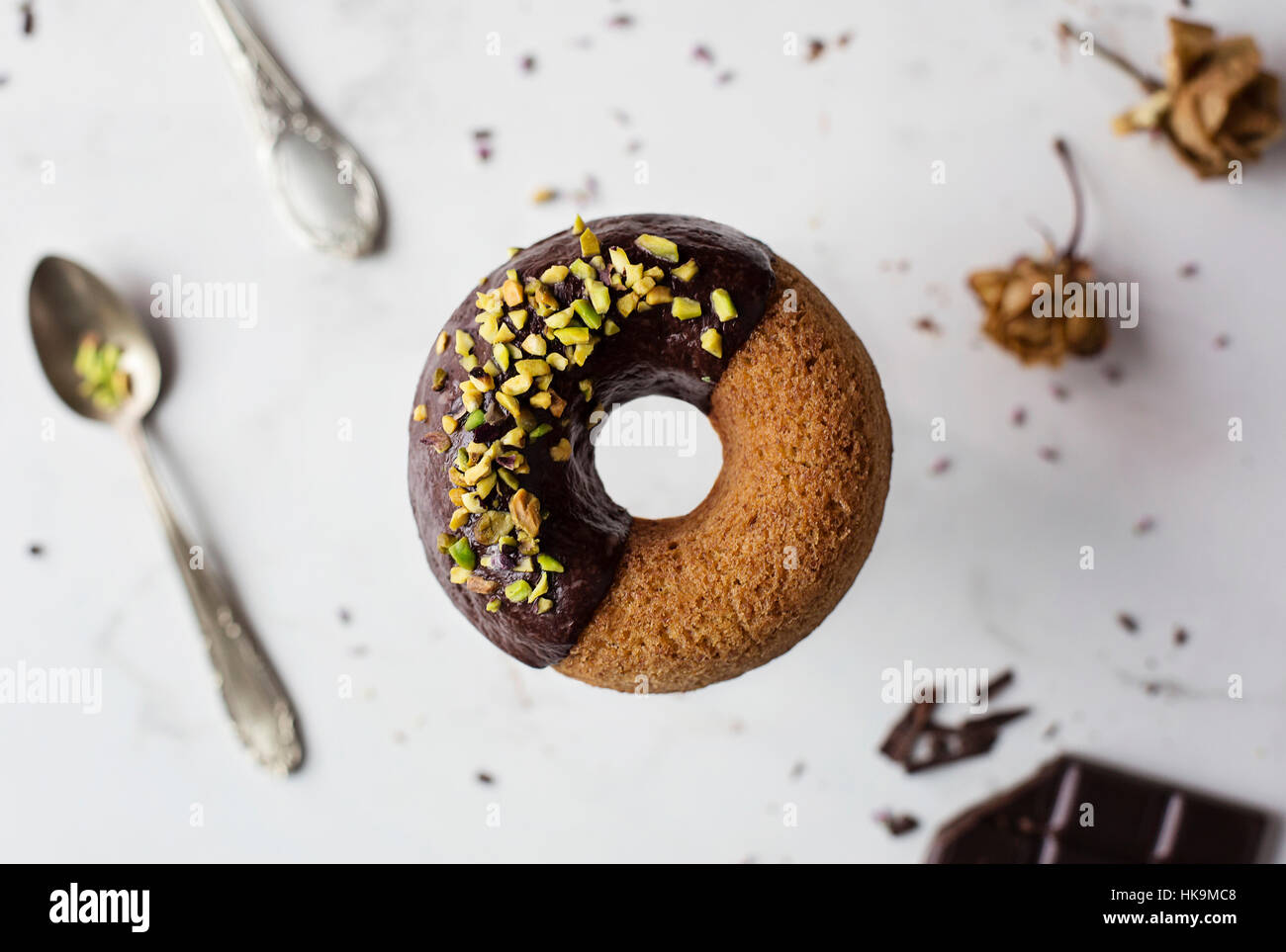 Donut with chocolate and pistachios on marble table Stock Photo