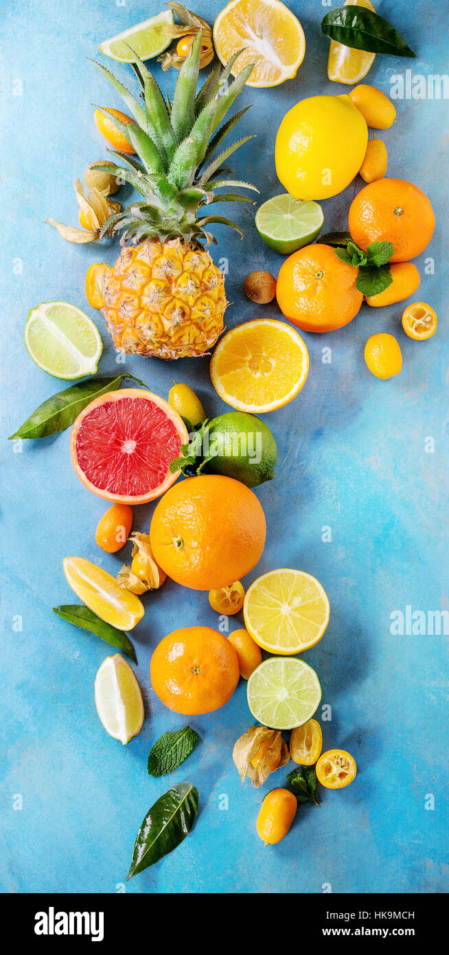 Variety of whole and sliced citrus fruits pineapple, grapefruit, lemon