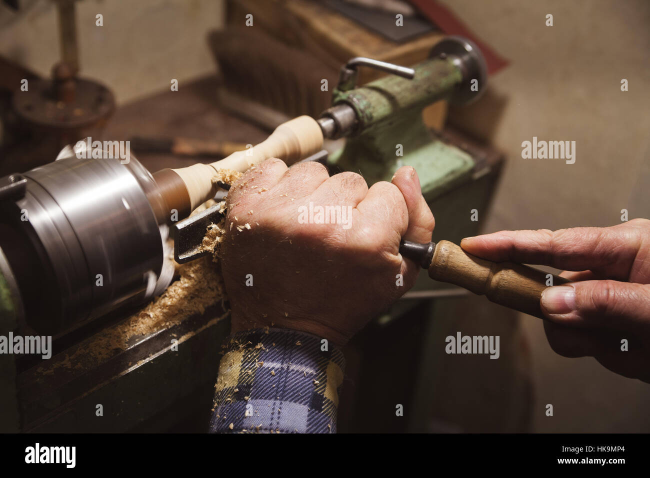 man's hands hold chisel near lathe Stock Photo