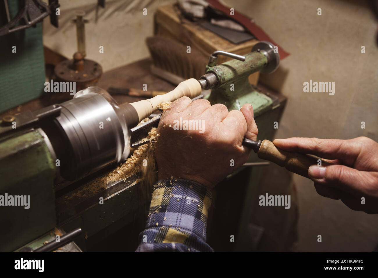 man's hands hold chisel near lathe Stock Photo