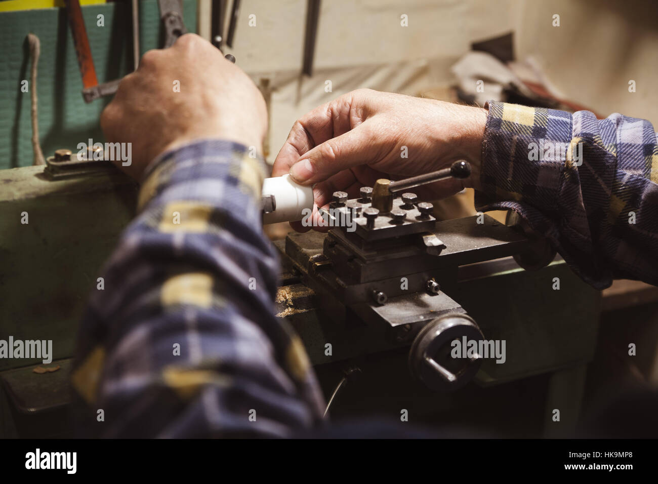 man's hands hold detail on lathe Stock Photo