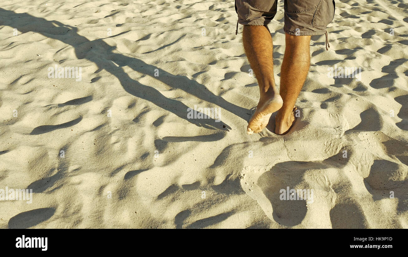 Male feet walking on sand Stock Photo - Alamy