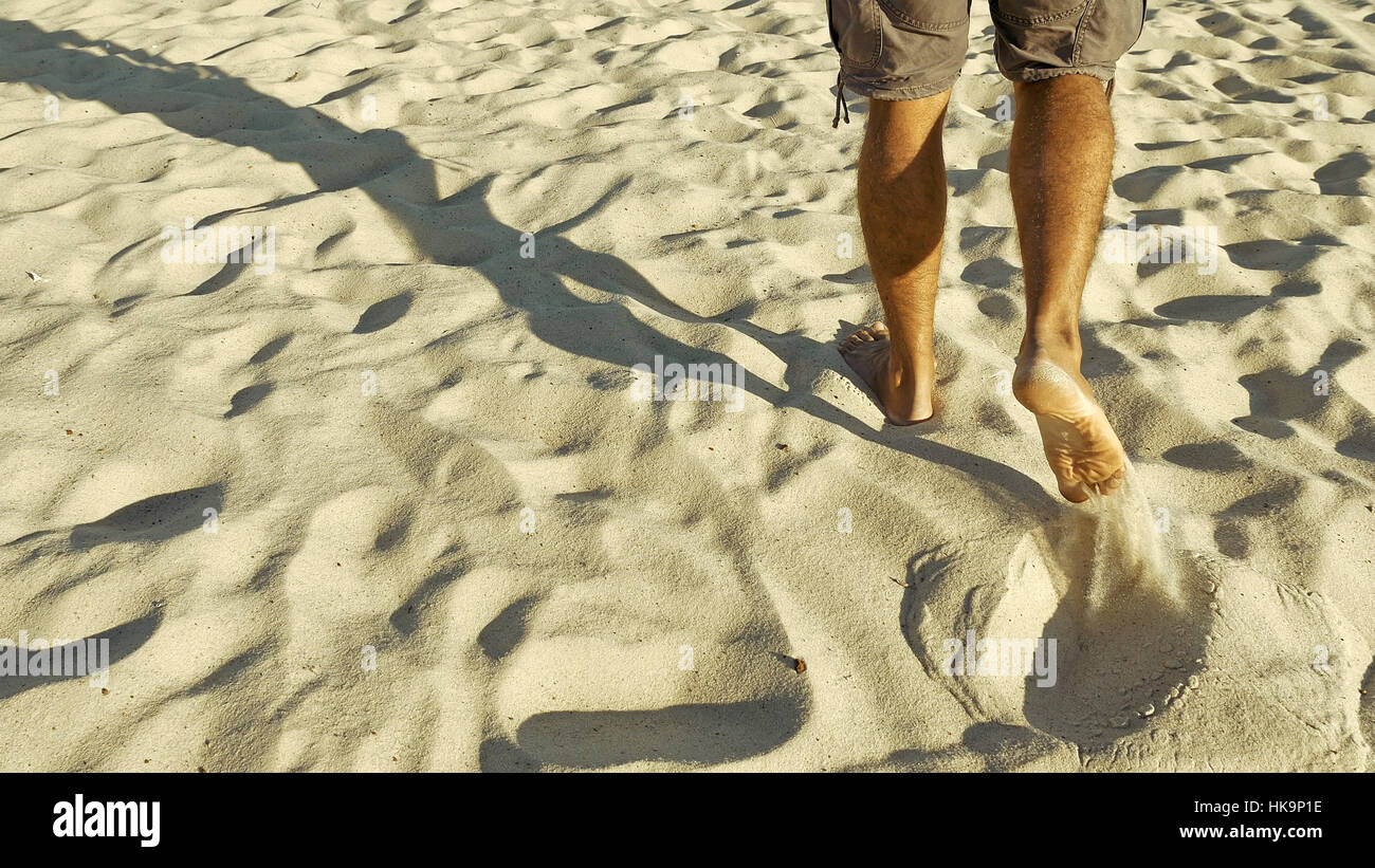 Male feet walking on sand Stock Photo