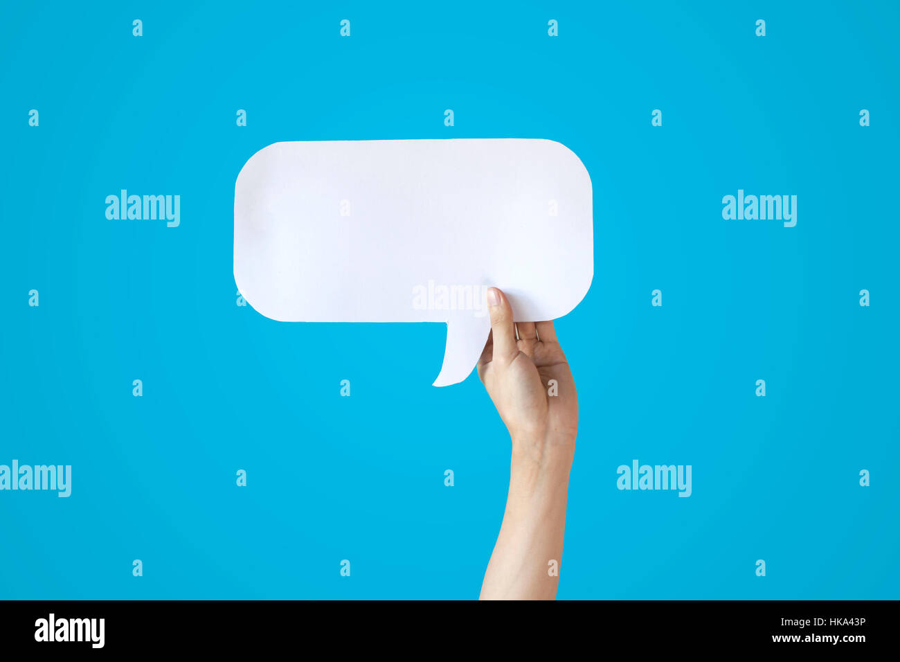 Human Hands Holding White Speech Bubble Over Blue Background Balloon
